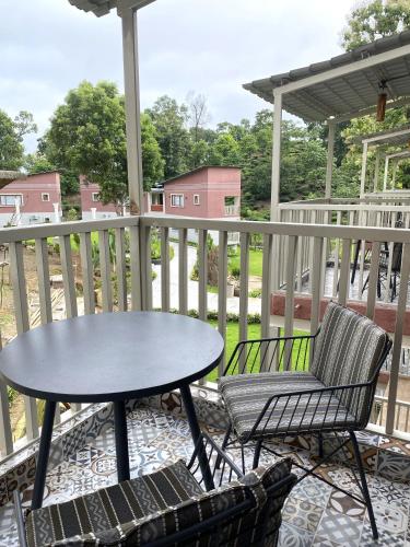 a table and two chairs on a porch with a table at Red River Retreat in Hatikhuli
