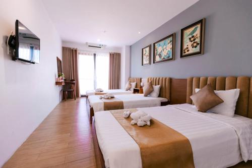 a hotel room with two beds and a couch at Gardenia Hue Hotel in Hue