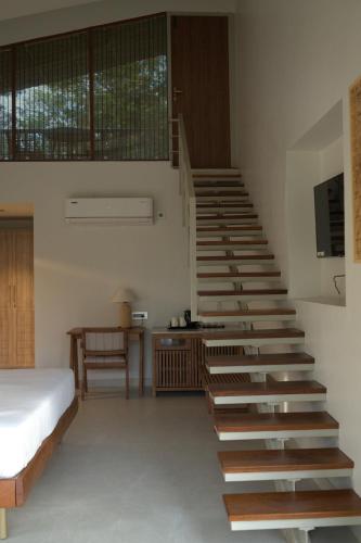 a bedroom with a stairway with a bed and a bed at Red River Retreat in Hatikhuli