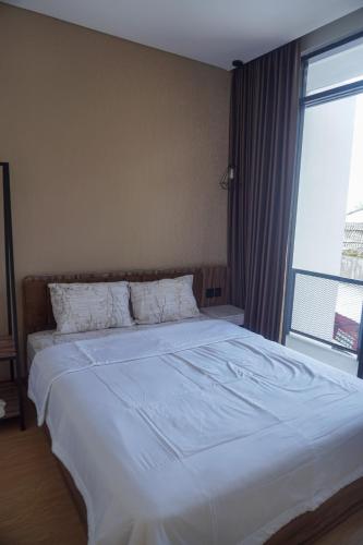 a large bed in a bedroom with a large window at Villa DeValley A9 Batu in Tlekung