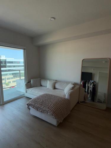 ein Wohnzimmer mit einer weißen Couch und einem großen Spiegel in der Unterkunft Elevated Escape Luxury 1BR in Hollywood in Los Angeles