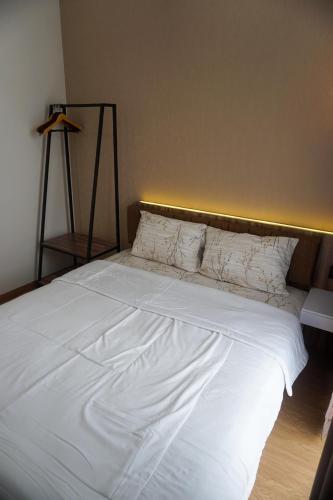 a large white bed with a wooden head board at Villa DeValley A9 Batu in Tlekung