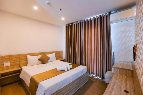 a bedroom with a bed and a window at Gardenia Hue Hotel in Hue