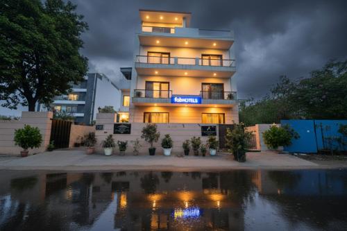 a building with a reflection in a pool of water at FabHotel AM Bliss in Gurgaon