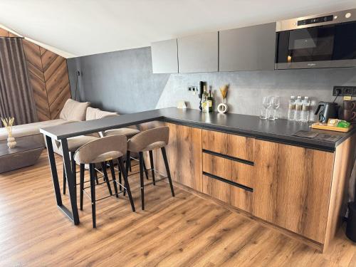 a kitchen with a counter and stools in a room at Didukh Eco Hotel&Spa in Bukovel