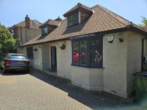 a house with a car parked outside of it at Stunning 4 bed house with huge garden and parking in Cheam