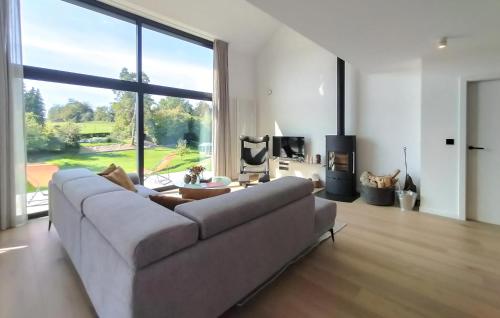 a living room with a couch and a large window at Stunning Home In Durbuy With Sauna in Tohogne
