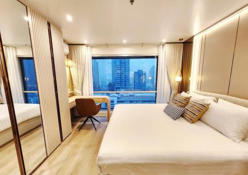 Una cama o camas en una habitación de คอนโดสุขุมวิทสวีท เรียบหรู อบอุ่น ครบครัน