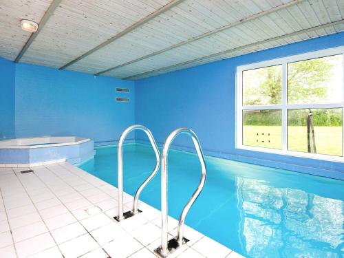 a large swimming pool with blue walls and a tub at Luxury Pool House by Sea - By Traum Ferienwohnungen in Nordborg