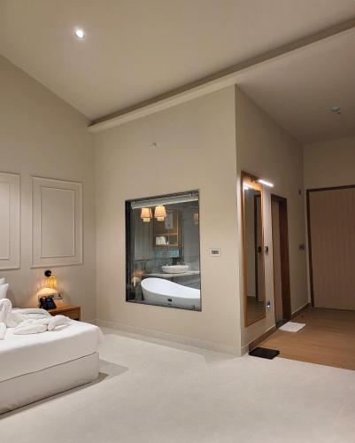 a bedroom with a white bed and a bath room at Red River Retreat in Hatikhuli