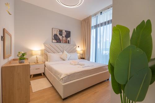 a bedroom with a white bed and a plant at Stylish 3BR - Maryah Vista Luxe Escape in Abu Dhabi