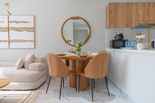 a living room with a table and chairs and a mirror at Stylish 3BR - Maryah Vista Luxe Escape in Abu Dhabi