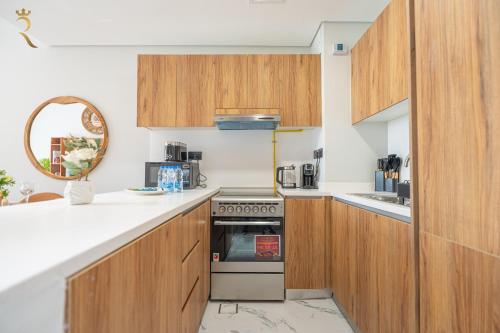 a kitchen with wooden cabinets and a stove at Stylish 3BR - Maryah Vista Luxe Escape in Abu Dhabi