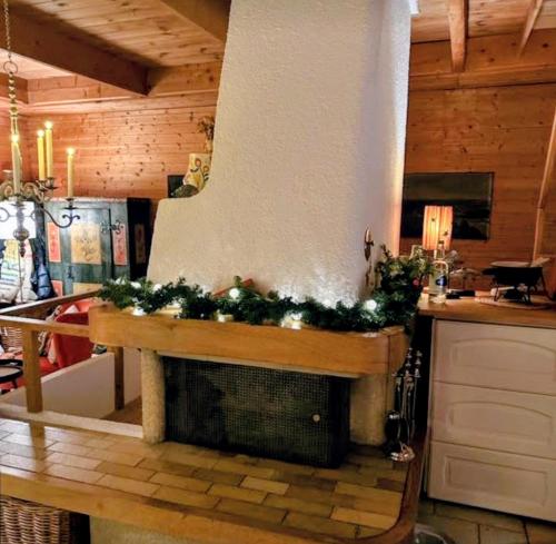a kitchen with a fireplace with christmas decorations on it at Mont Blanc Chalet in Grandevent