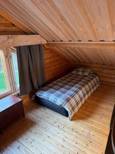 a bed in a room with a wooden ceiling at Villa Hackberry Hill in Rovaniemi