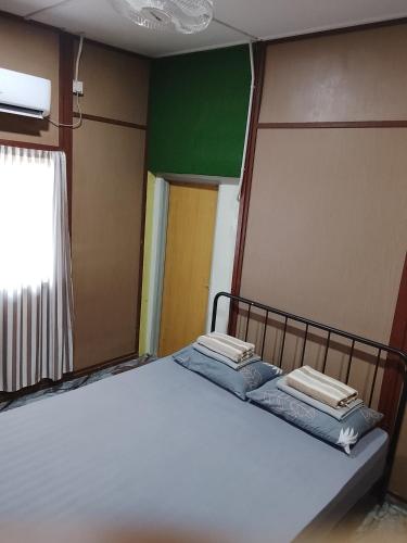 a large bed in a room with a green wall at Benteng Taman Negara in Jerantut