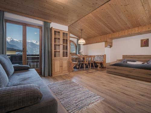 Sala de estar con cama y mesa de comedor en Apart. Mountainlovers, en Hainzenberg