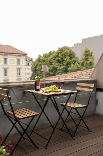 a table with two chairs and wine glasses on a balcony at Donizetti Studios in Bergamo