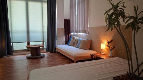 a room with a bed and a couch and a lamp at 山露露品茶 70年代老房子 二樓背包 4-5樓合併 六人包層 Te en Te' Guesthouse in Tainan