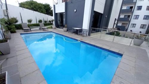 a large blue swimming pool in front of a building at The Sweet Serenity Suite in Midrand