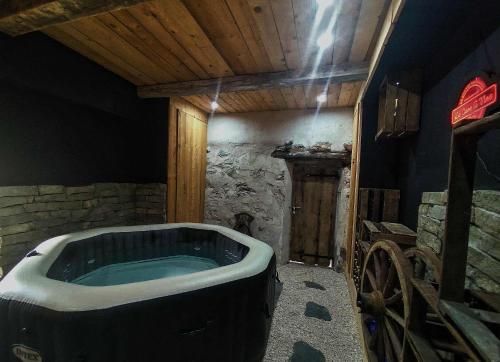 a bath tub in a room with a stone wall at LA GRANGE SAVOYARDE-Spa-Piscine-Proche lac-Charme-Détente- 3 Etoiles in Lathuile