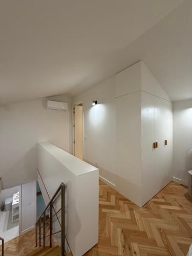a staircase in a room with white walls and wooden floors at Luxury Duplex Apartment with terrace by Perpetual Relax in Braga