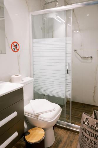 a bathroom with a toilet and a glass shower at ALEXANDRA Boutique Residence Downtown in Alexandroupoli