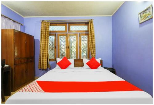 une chambre avec un lit avec des oreillers rouges et une fenêtre dans l'établissement Hotel S S- Residency Near Mall Road-NAINI LAKE - Free Parking - Jungle Safari & Restaurant Facilities - Hygiene and Spacious Room - The Best Hotel with Mountain Views, à Nainital