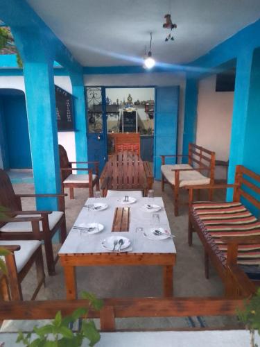 a restaurant with wooden tables and chairs and blue walls at panorama view in Chefchaouen
