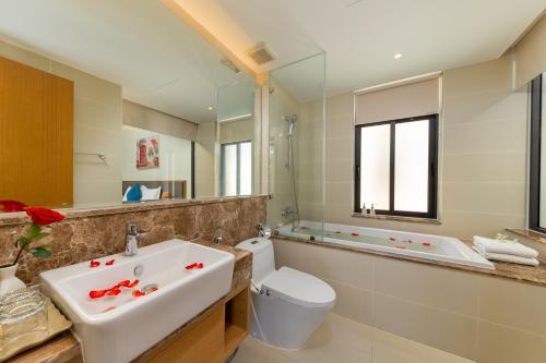 a bathroom with a sink and a toilet and a tub at Seaside Escape Villa in Cam Lâm