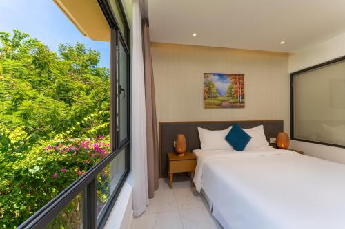 a bedroom with a bed and a large window at Seaside Escape Villa in Cam Lâm
