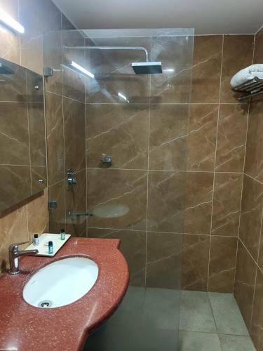 a bathroom with a sink and a glass shower at The Lohmod Premier Aerocity on NH-8 Mahipalpur Delhi Airport in New Delhi