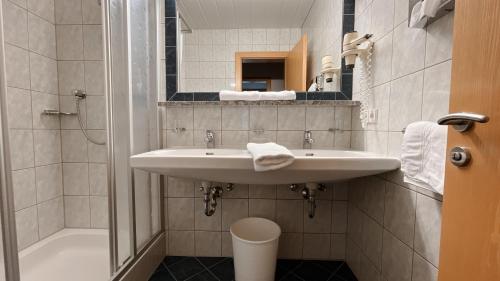 a white bathroom with a sink and a shower at Chasa Monthani in Ischgl