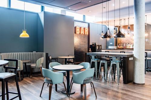 a restaurant with tables and chairs and a bar at Premier Inn Hannover City University in Hannover
