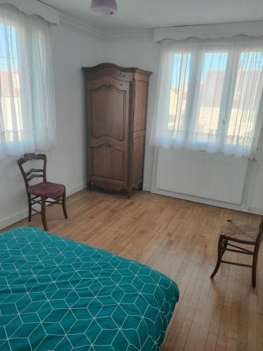 a bedroom with a bed and a chair and windows at maison individuelle in Franconville
