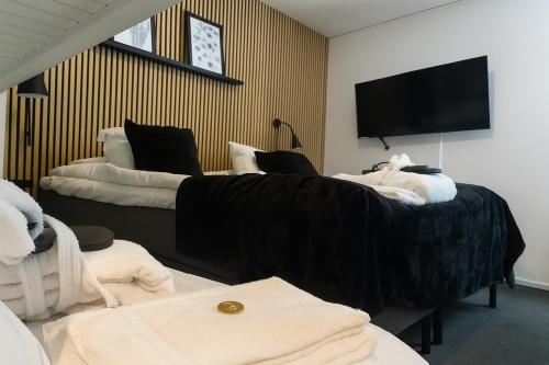 a hotel room with two beds and a flat screen tv at STF Korrö Gårdshotell - B&B in Linneryd