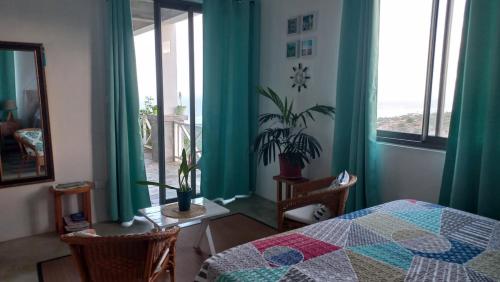 a bedroom with green curtains and a bed and a window at Studio Amanda in Nouvelle Découverte