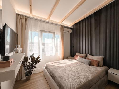 Un dormitorio con una cama grande y una ventana. en Luxury Penthouse, en Tirane