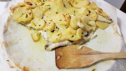 a plate of food with a fork and a pizza at Studio Amanda in Nouvelle Découverte