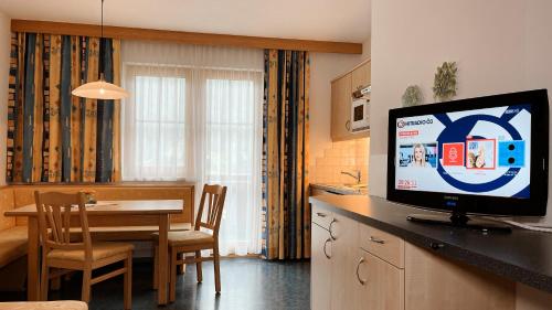 a kitchen and dining room with a television on a counter at Chasa Monthani in Ischgl