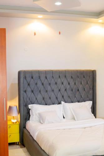 BwebajjaにあるToria Homesのベッドルーム1室(グレーのヘッドボード付きベッド1台付)