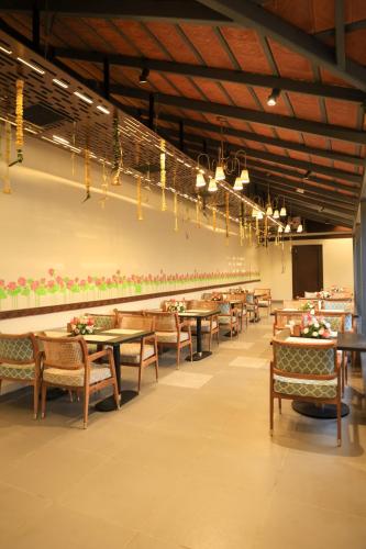 a dining room with tables and chairs and chandeliers at Quad Hotels Hyderabad in Hyderabad
