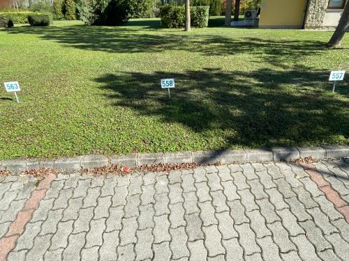 two signs on the grass in a yard at Büki Villa Park Apartman in Bük