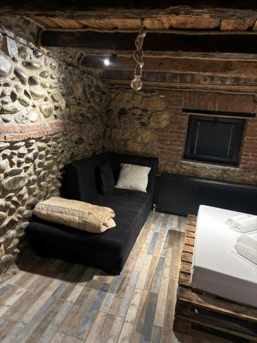 sala de estar con sofá en una pared de ladrillo en Cozy Spot, en Kutaisi