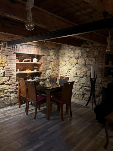 Un comedor con mesa y sillas de madera. en Cozy Spot, en Kutaisi