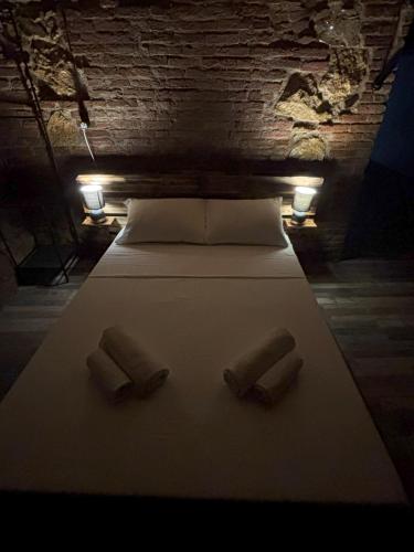 Una cama con dos almohadas y dos luces. en Cozy Spot, en Kutaisi