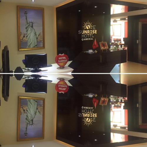 a store window with posters of the statue of liberty at Sunrise Hotel Cameria in Durrës