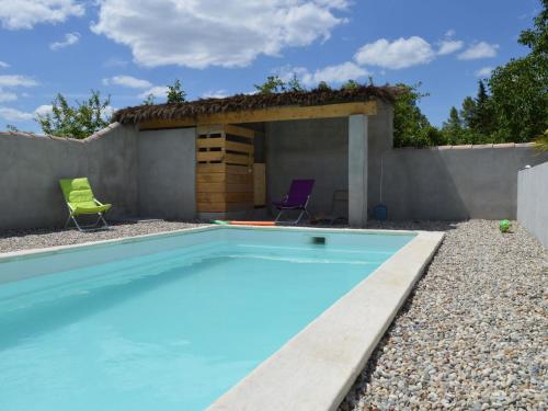 a swimming pool with two chairs and a house at Serene Holiday Home in Pradons with Swimming Pool in Pradons