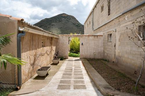 an alley in an old building with a mountain in the background at Vivienda de Turismo Rural Granja La Lomica in Ladruñán