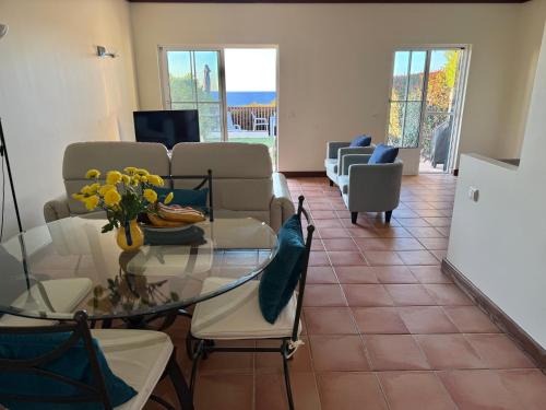 a living room with a glass table and chairs at Casa Rosa Azul - Terracos de Benagil (Cliffside) in Benagil